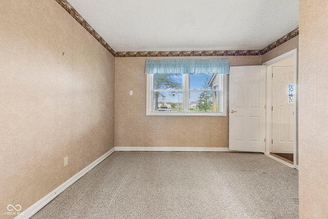 spare room featuring plenty of natural light and baseboards