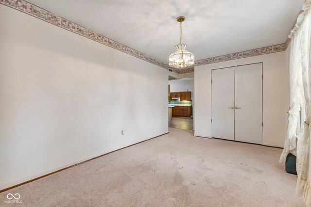 unfurnished dining area with a chandelier, carpet floors, and baseboards