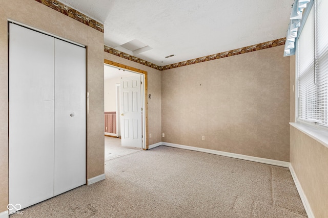 unfurnished bedroom with carpet floors, a closet, and baseboards