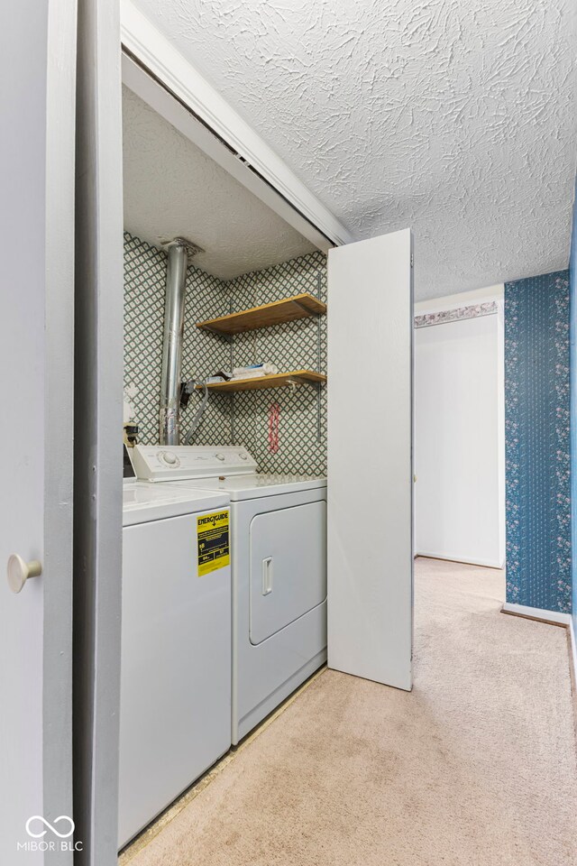 clothes washing area featuring light colored carpet and washer and dryer