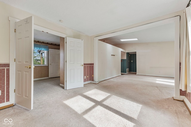 unfurnished room with carpet and baseboards