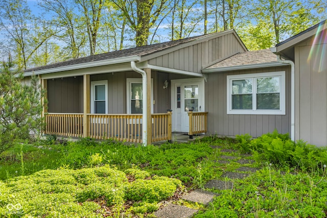 view of front of home with roof with shingles and a porch