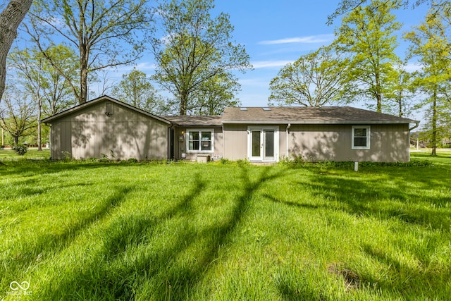 back of house featuring french doors and a lawn