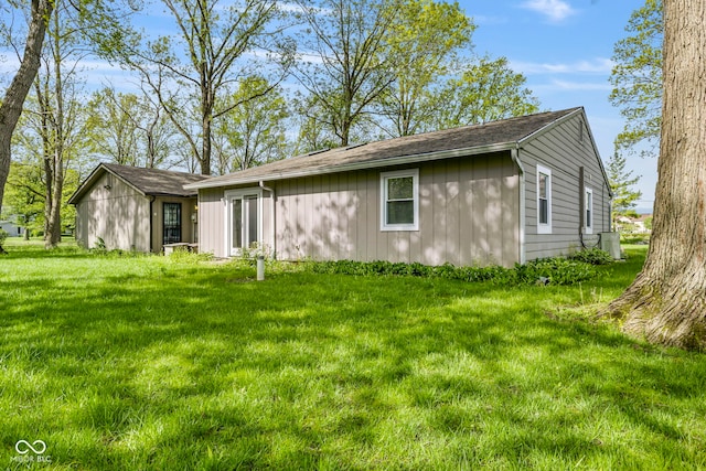 view of side of property featuring a yard and central AC