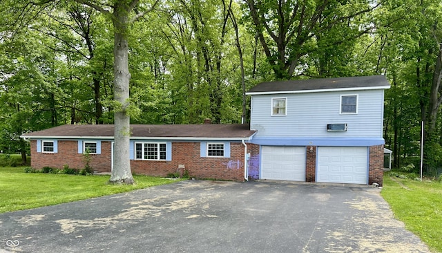 206 Windemere Rd, West Terre Haute, IN 47885 - view of front facade with asphalt driveway, an attached garage, and brick siding