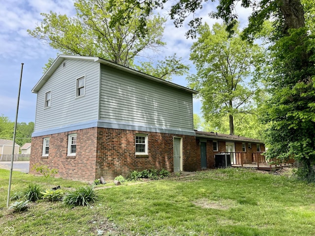206 Windemere Rd, West Terre Haute, IN 47885 - back of house featuring brick siding, a wooden deck, a yard, and central AC