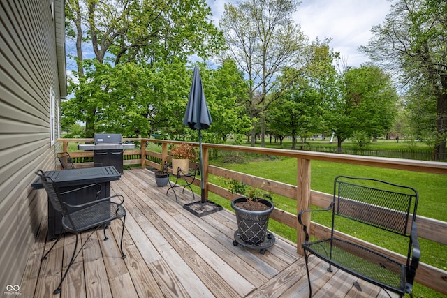 wooden deck featuring grilling area and a lawn