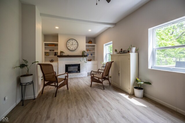living area featuring a fireplace, light wood-style flooring, baseboards, a ceiling fan, and recessed lighting