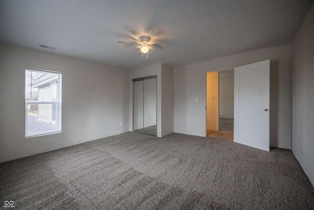unfurnished bedroom featuring carpet flooring, a closet, and ceiling fan