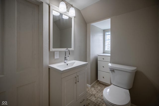 half bath with toilet, vanity, baseboards, and lofted ceiling