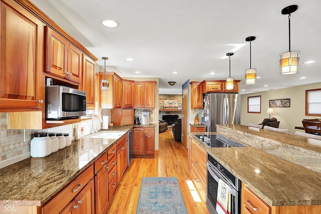 2769 S 800 W, Indianapolis, IN 46239 - kitchen featuring appliances with stainless steel finishes, a sink, light wood-style flooring, brown cabinetry, and recessed lighting