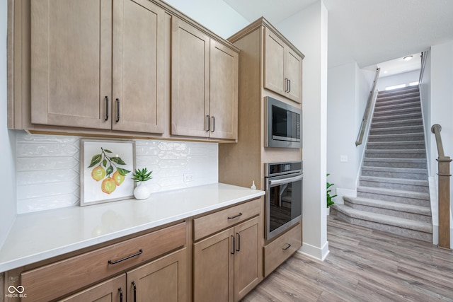 15792 Wiseman Dr, Fishers, IN 46040 - kitchen featuring stainless steel appliances, tasteful backsplash, light wood-style floors, light countertops, and baseboards