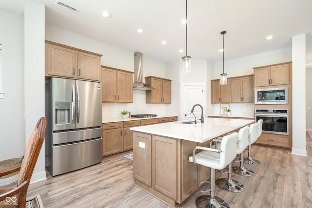 15792 Wiseman Dr, Fishers, IN 46040 - kitchen featuring appliances with stainless steel finishes, a sink, wall chimney exhaust hood, backsplash, and light wood finished floors