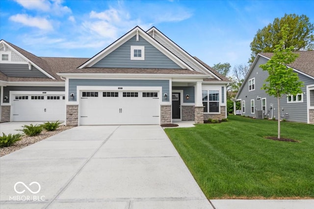 craftsman inspired home with stone siding, a front lawn, driveway, and an attached garage