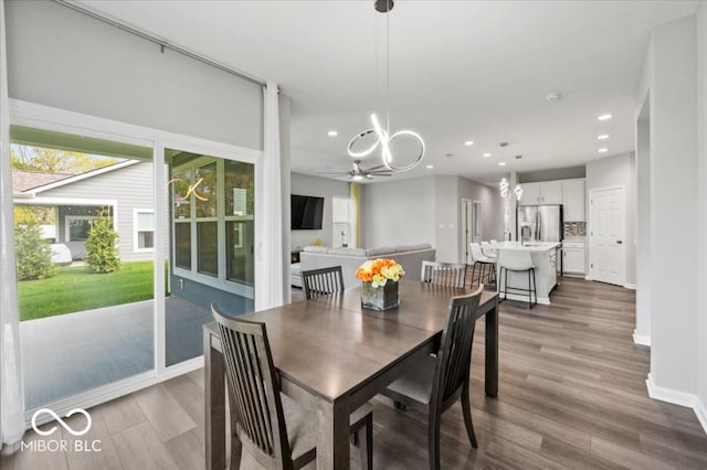 dining space with wood finished floors, recessed lighting, baseboards, a chandelier, and ceiling fan