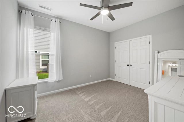 unfurnished bedroom with light carpet, a closet, baseboards, and a ceiling fan