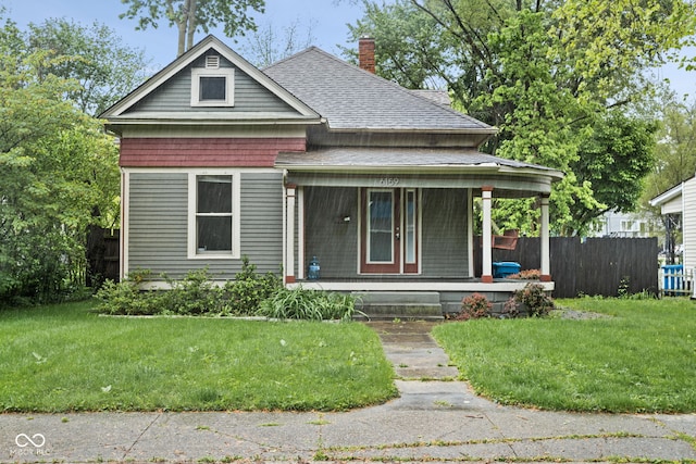 view of front of house featuring covered porch, roof with shingles, and a chimney