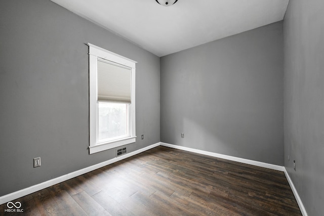 unfurnished room featuring dark wood-type flooring and baseboards