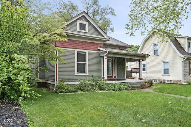view of front of home featuring covered porch, a front yard, and a shingled roof