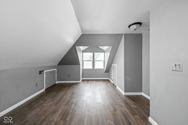 bonus room featuring dark wood finished floors, lofted ceiling, and baseboards