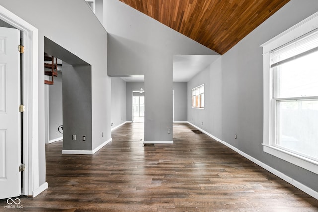 empty room featuring wood ceiling, baseboards, dark wood-style floors, and high vaulted ceiling