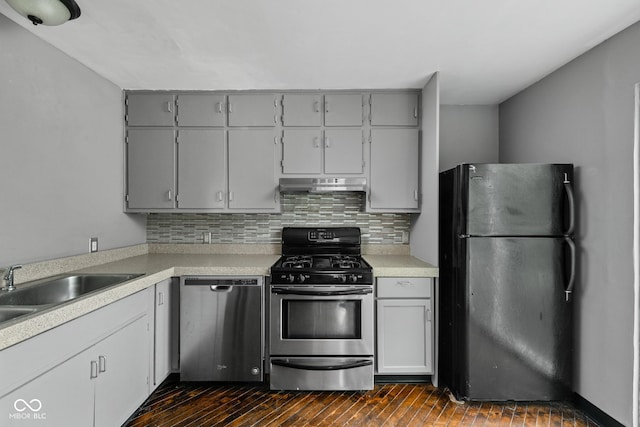 kitchen with appliances with stainless steel finishes, gray cabinets, backsplash, and light countertops