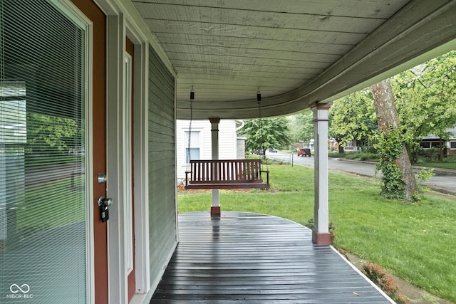 wooden terrace with a porch and a lawn