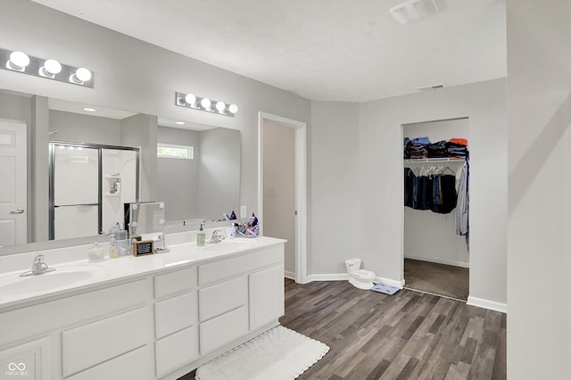 4032 Stubbington Ln, Indianapolis, IN 46239 - full bathroom with wood finished floors, a shower stall, baseboards, double vanity, and a walk in closet