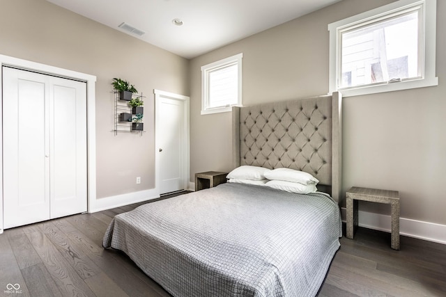 bedroom featuring wood finished floors, baseboards, and a closet