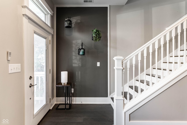 foyer entrance featuring dark wood finished floors and stairs