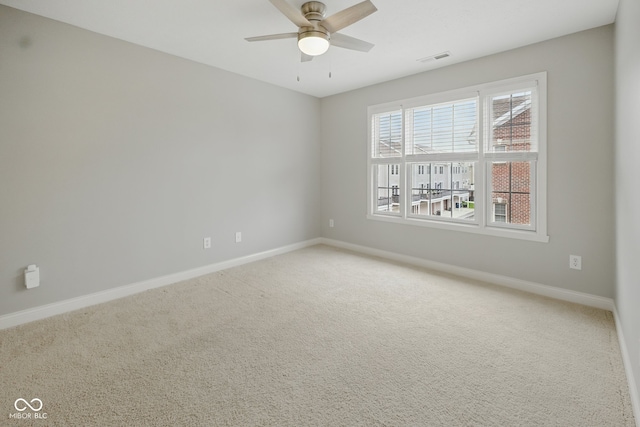 carpeted spare room featuring baseboards and ceiling fan