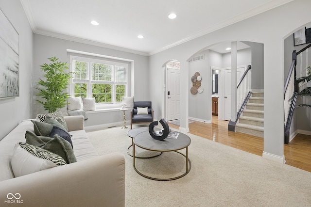 living room featuring carpet floors, arched walkways, baseboards, recessed lighting, and stairway