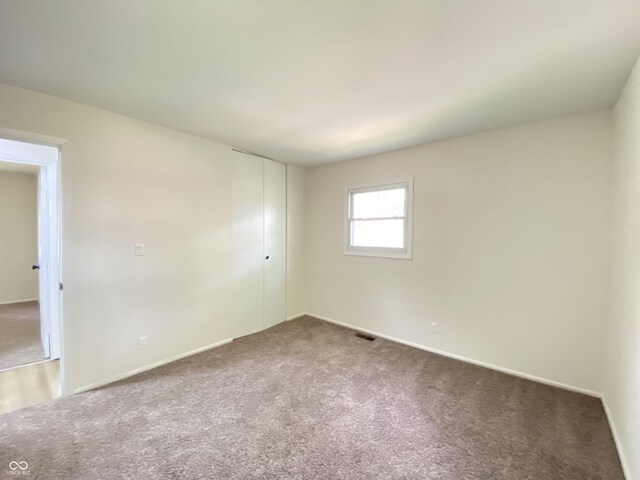 unfurnished room featuring carpet flooring and baseboards