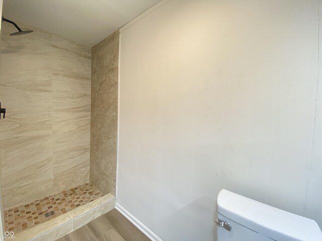 full bath featuring a stall shower, toilet, and wood finished floors