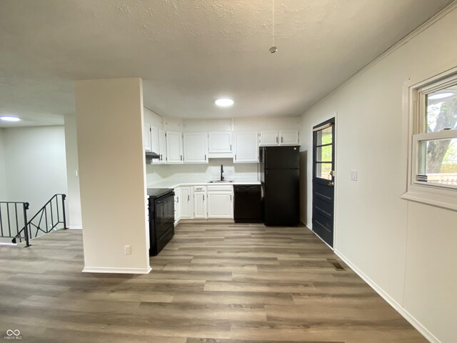 kitchen with black appliances, a sink, white cabinetry, healthy amount of natural light, and recessed lighting