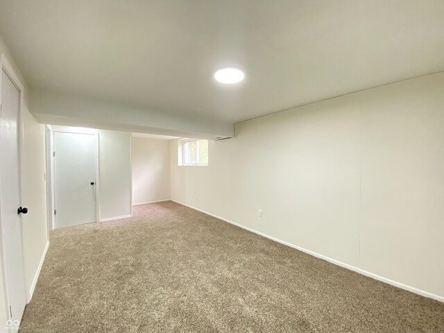 basement featuring carpet flooring and baseboards