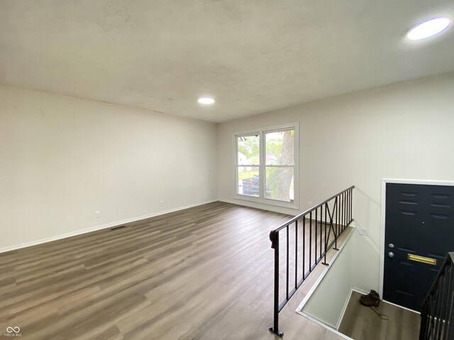 unfurnished room featuring wood finished floors, baseboards, and recessed lighting