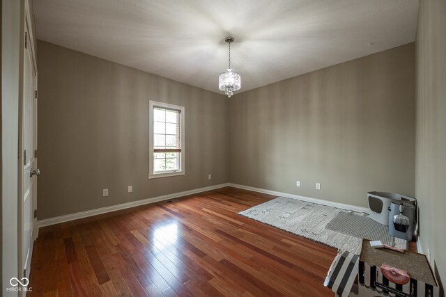 4890 Benthaven Dr E, Bargersville, IN 46106 - empty room featuring a chandelier, baseboards, and wood finished floors
