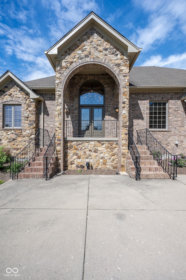 4890 Benthaven Dr E, Bargersville, IN 46106 - doorway to property featuring stone siding, roof with shingles, and brick siding