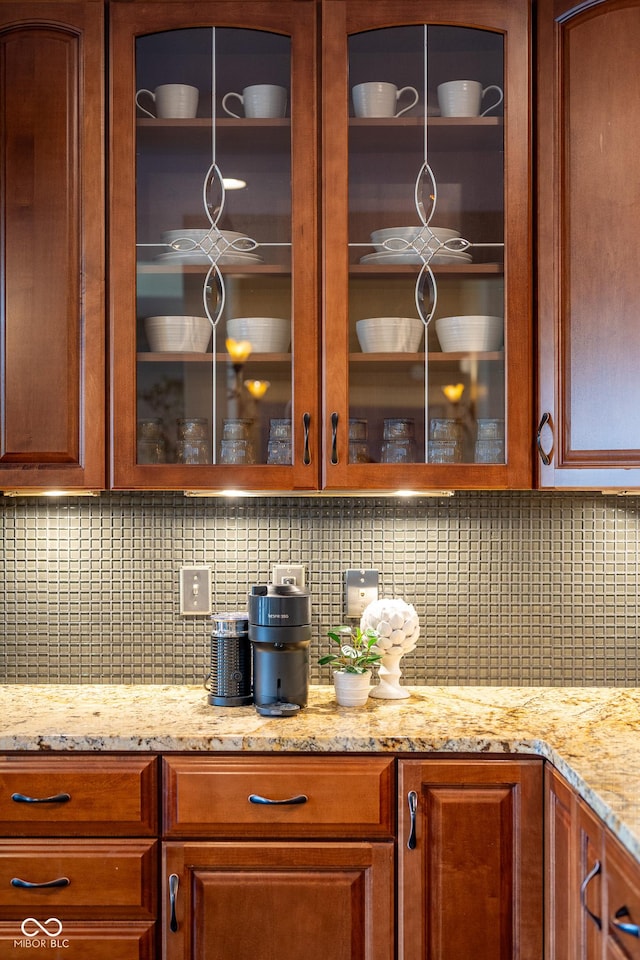 4890 Benthaven Dr E, Bargersville, IN 46106 - kitchen view of glass insert cabinets, tasteful backsplash, light stone countertops, and brown cabinetry