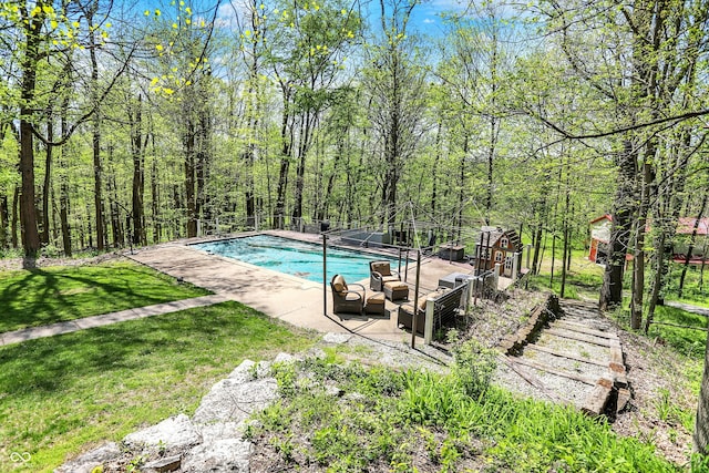 swimming pool featuring a patio and a yard