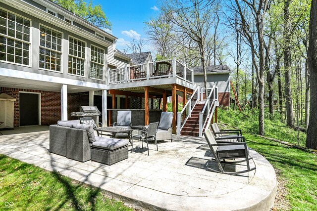 rear view of house featuring a wooden deck, a patio, an outdoor hangout area, stairs, and brick siding