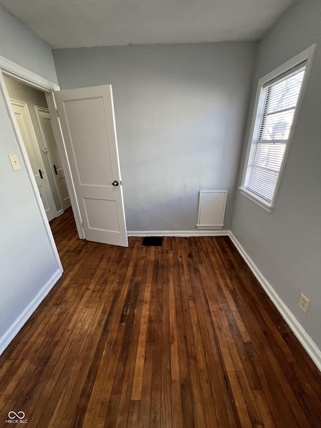 2037 Glenridge Dr, Indianapolis, IN 46218 - empty room featuring baseboards and dark wood-style flooring
