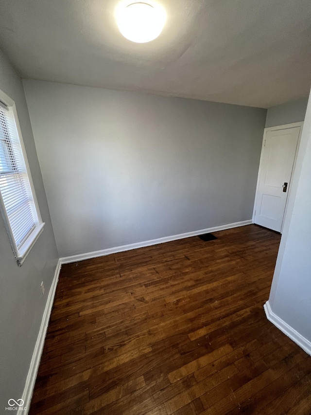 2037 Glenridge Dr, Indianapolis, IN 46218 - unfurnished room with dark wood-type flooring and baseboards