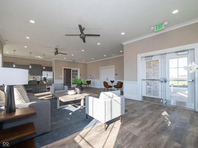 living area featuring french doors, ceiling fan, wainscoting, crown molding, and dark wood finished floors