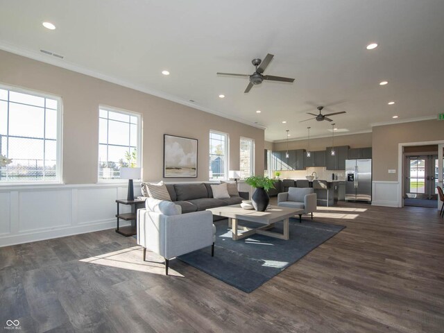 living area featuring ornamental molding, a ceiling fan, dark wood-style floors, a decorative wall, and recessed lighting