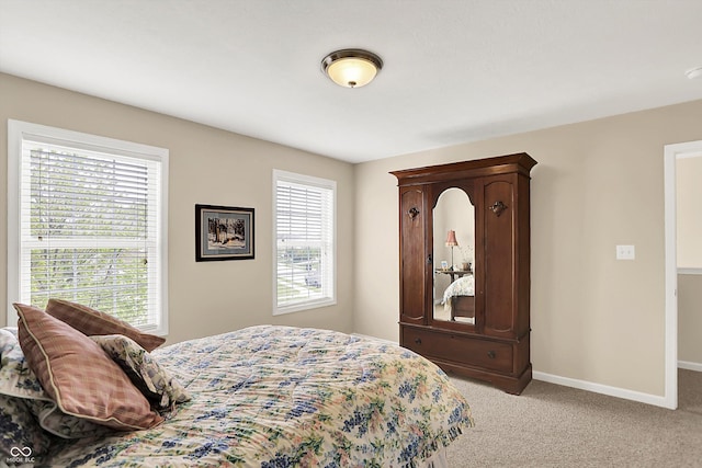 bedroom with light colored carpet and baseboards