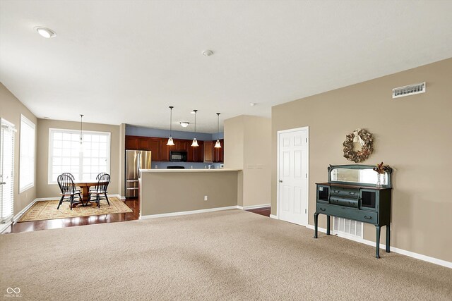 carpeted living area featuring baseboards