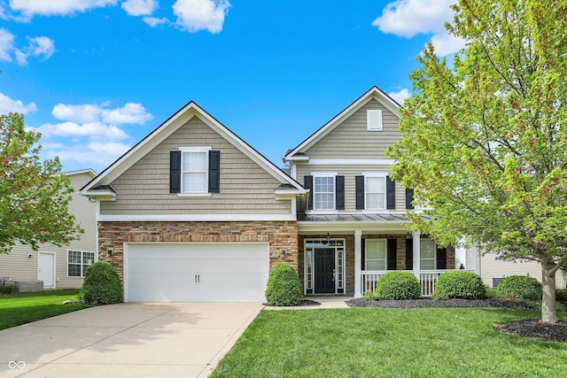 traditional-style house featuring a porch, an attached garage, concrete driveway, and a front yard