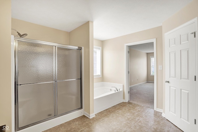 full bathroom with a shower stall, a bath, tile patterned flooring, and baseboards
